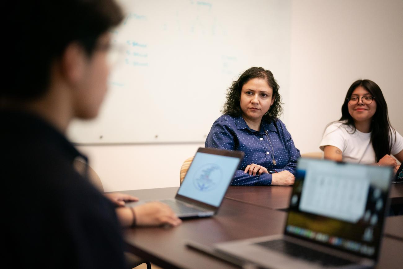 A professor listens intently to a student speaking.