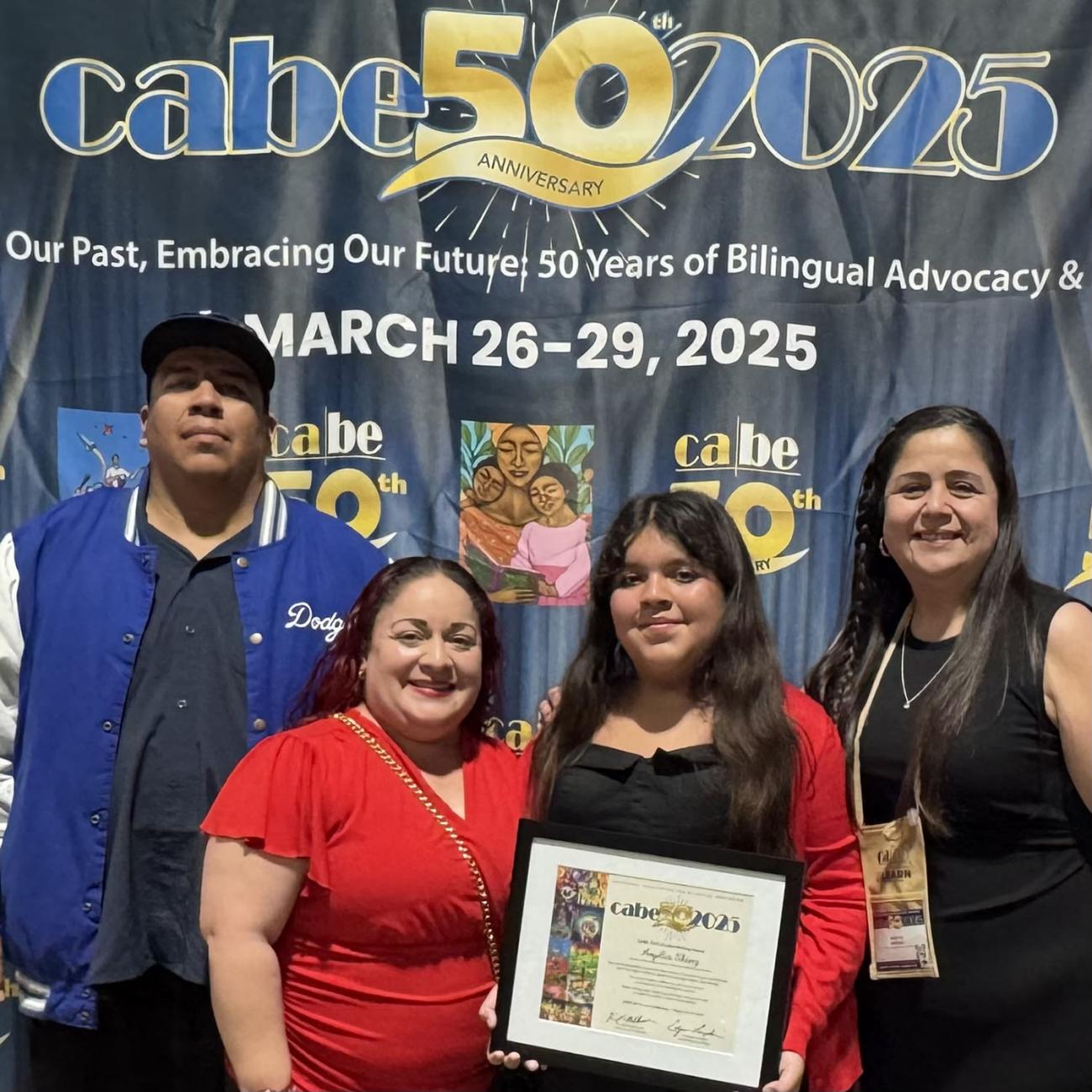 Mireya Jimenez posing with her student who won a poetry contest and her parents