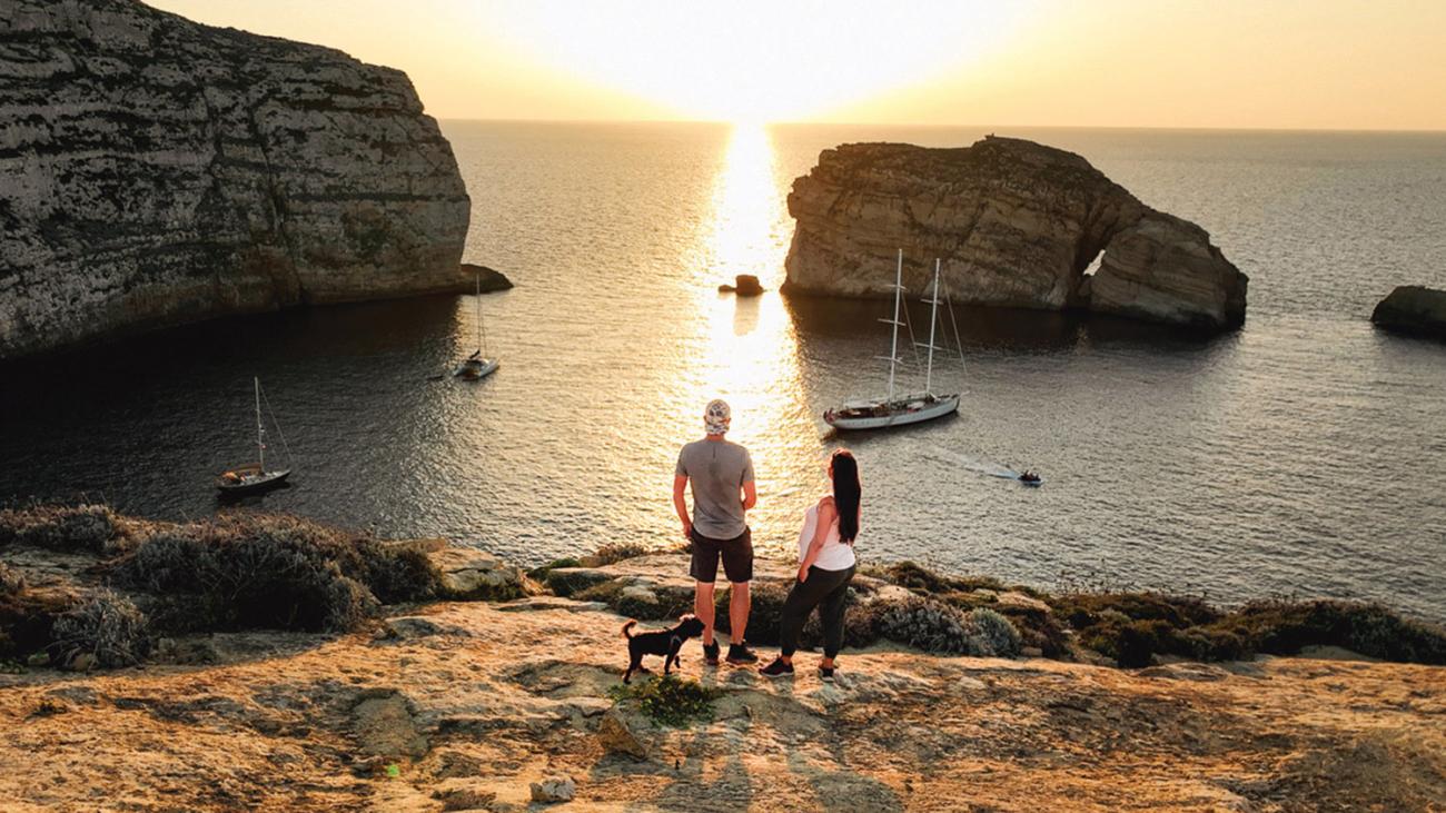 two people standing on cliff 