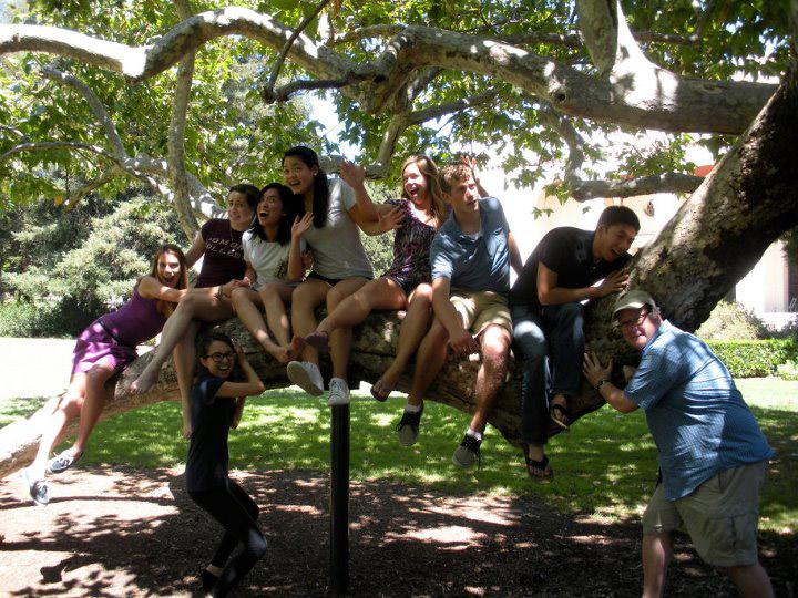 Prof. Karl Johnson and students on tree branch on campus.