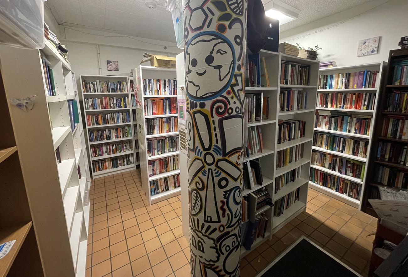 Room with many white shelves filled with books