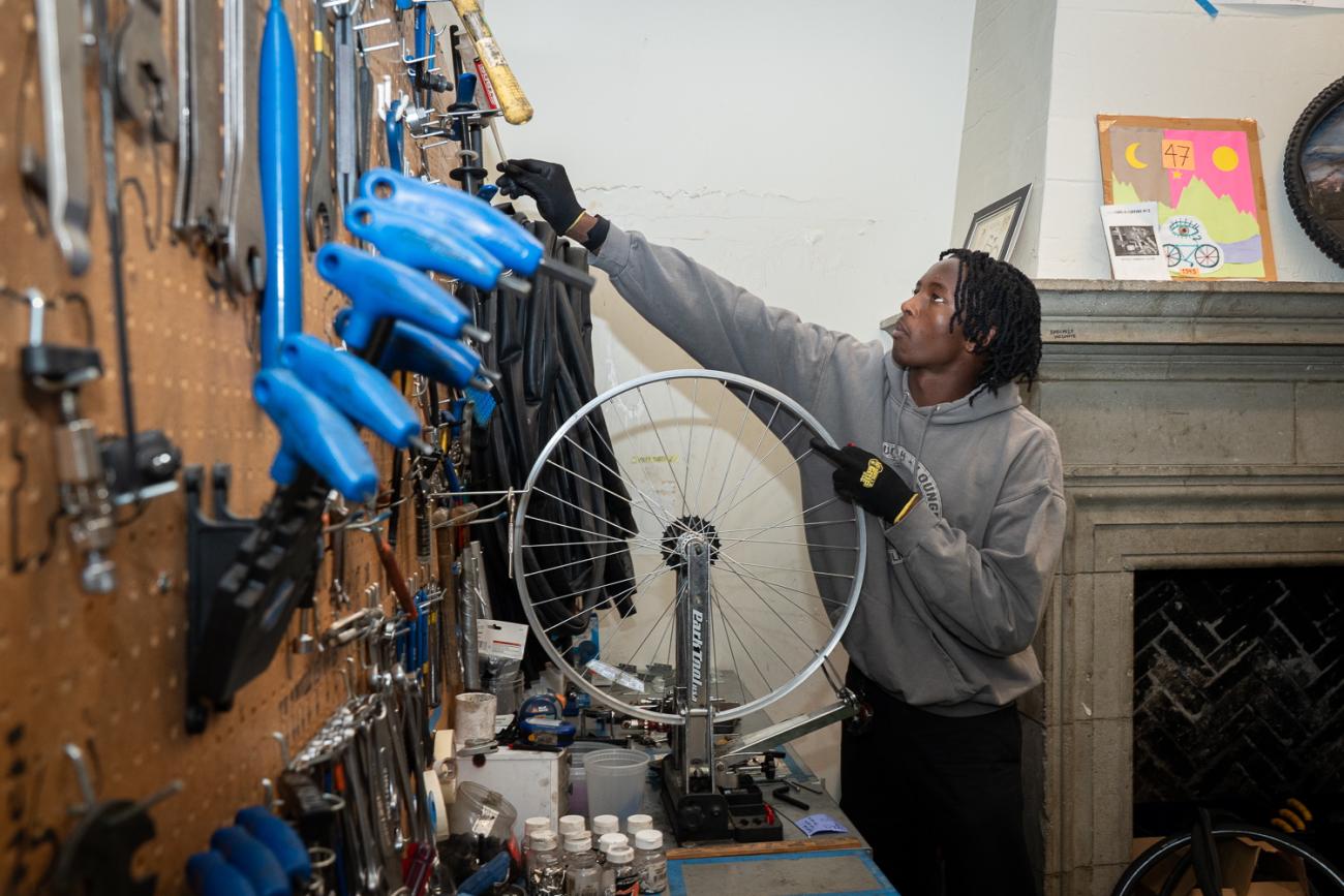 A young man fixes a bike tire