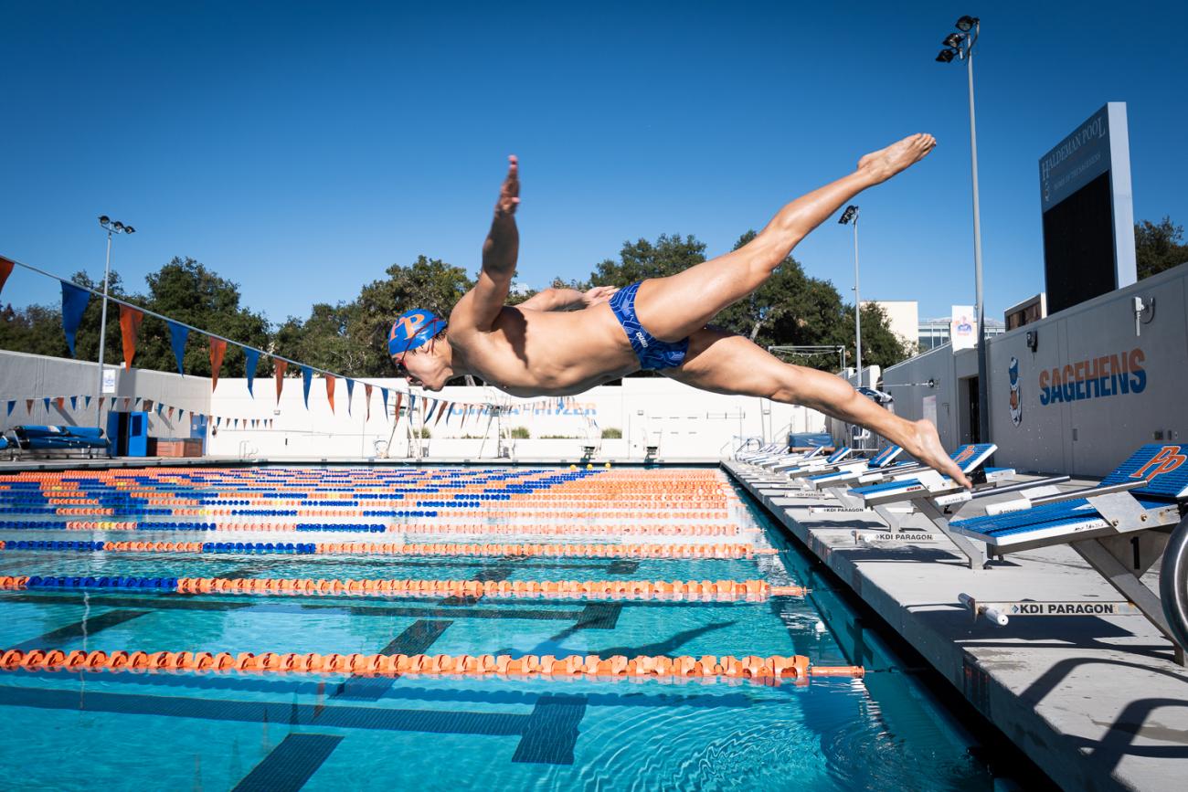 A man leaps into a pool