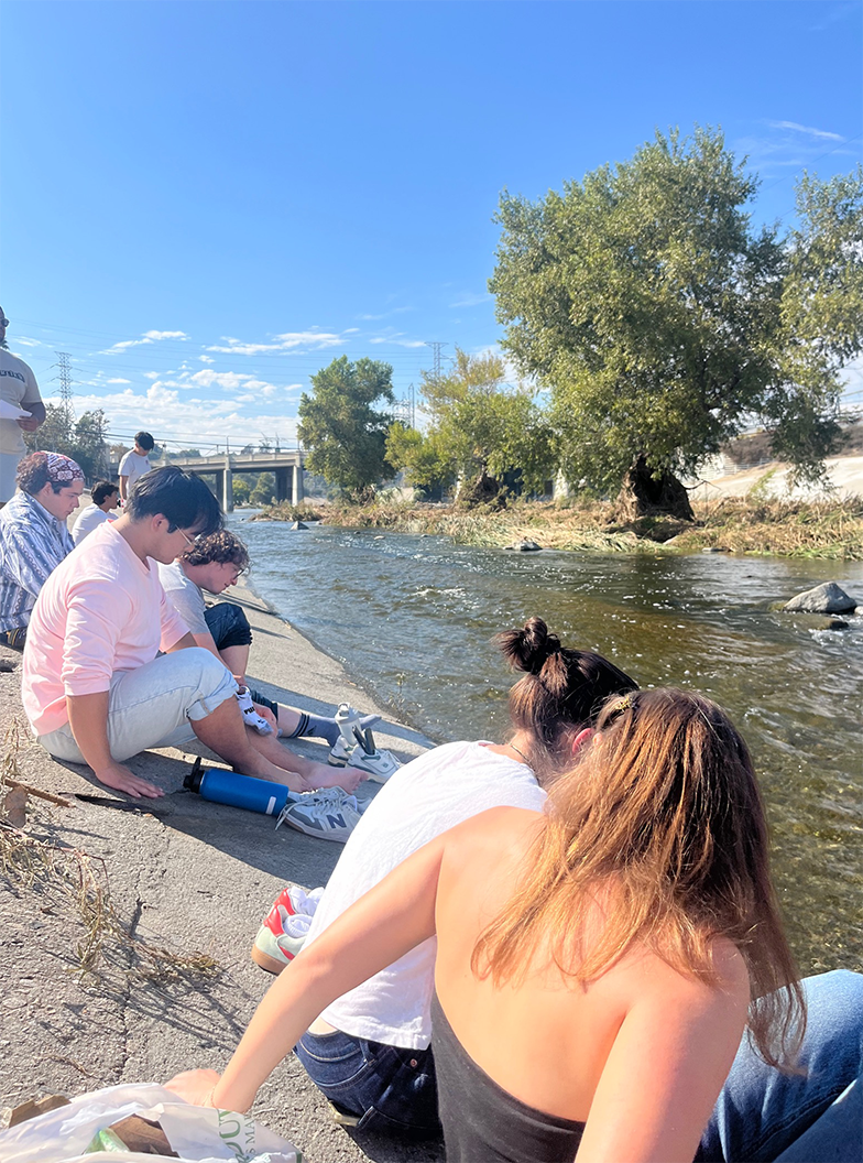 Students sit along the banks of the LA River