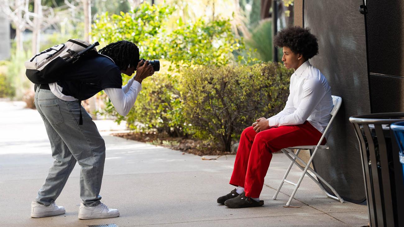 Student taking a headshot of another student