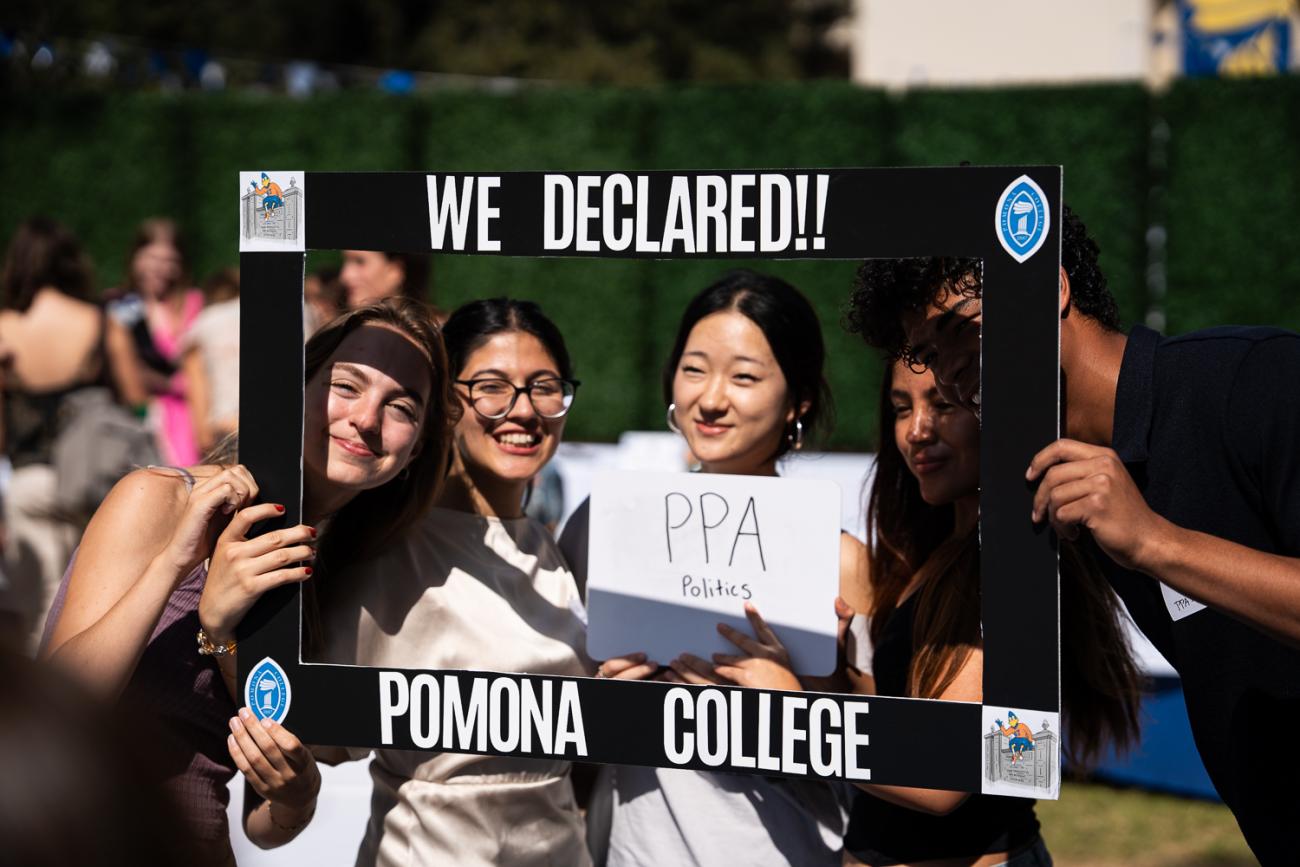 Students pose with a cardboard frame
