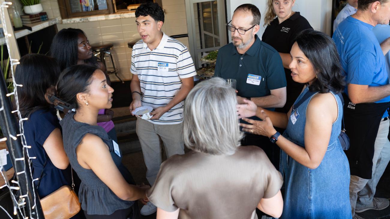 Students and alumni talking at mixer