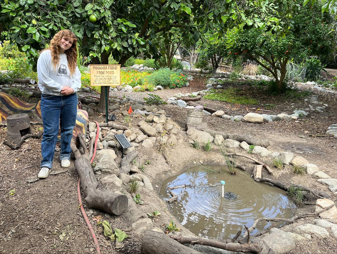 Anna Parrott stands by the small pond she created at the college's Farm.