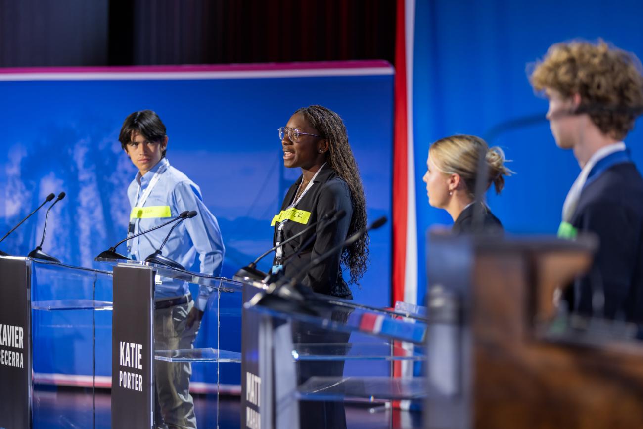 Students at podiums on stage