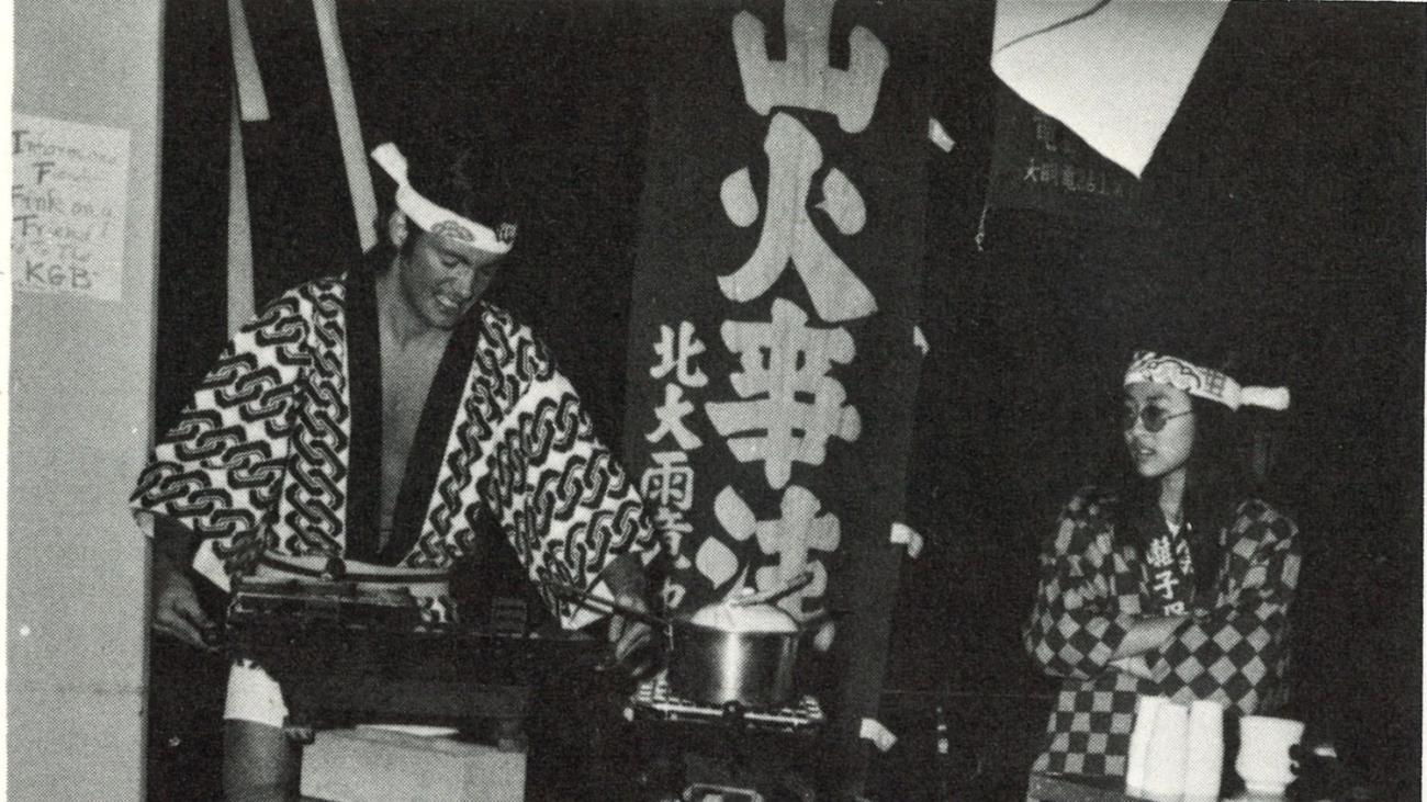 two students on stage in the dining hall