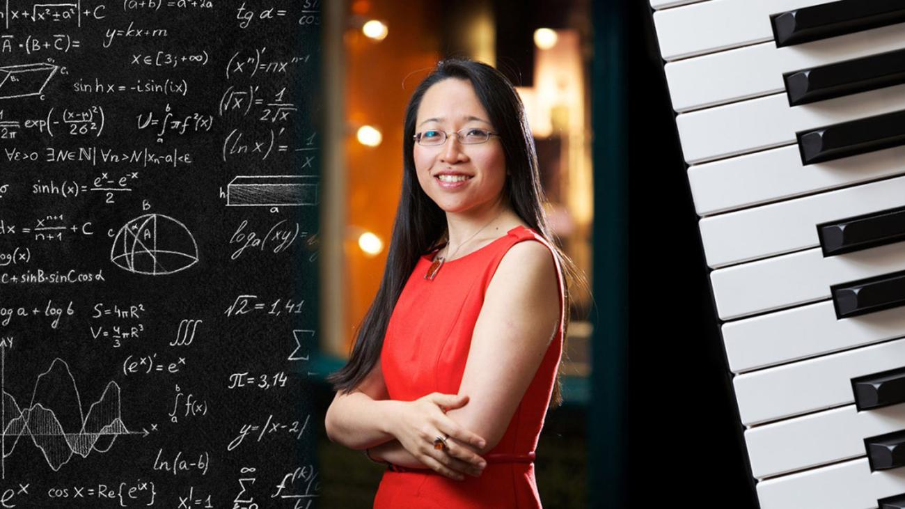 Eugenia Cheng between math on chalkboard on left and piano keyboard on right