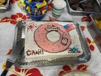 picture of a birthday cake with a donut logo on top
