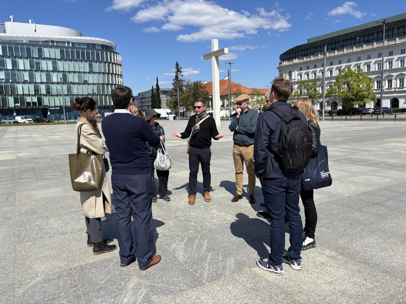 Mietek Boduszynski with tour group outside in Warsaw