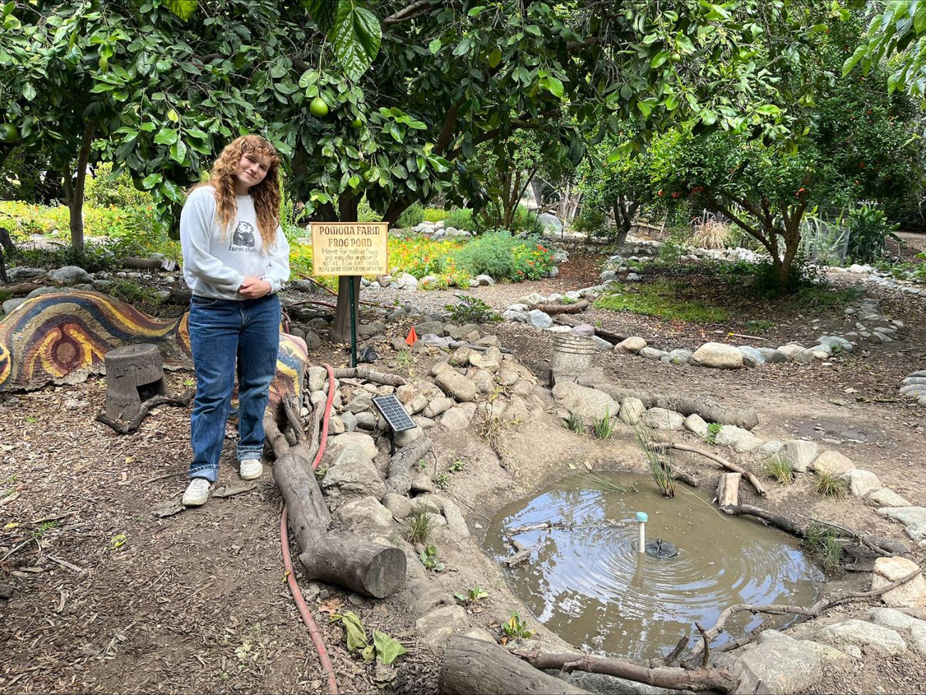 Student standing next to frog pond at The Farm