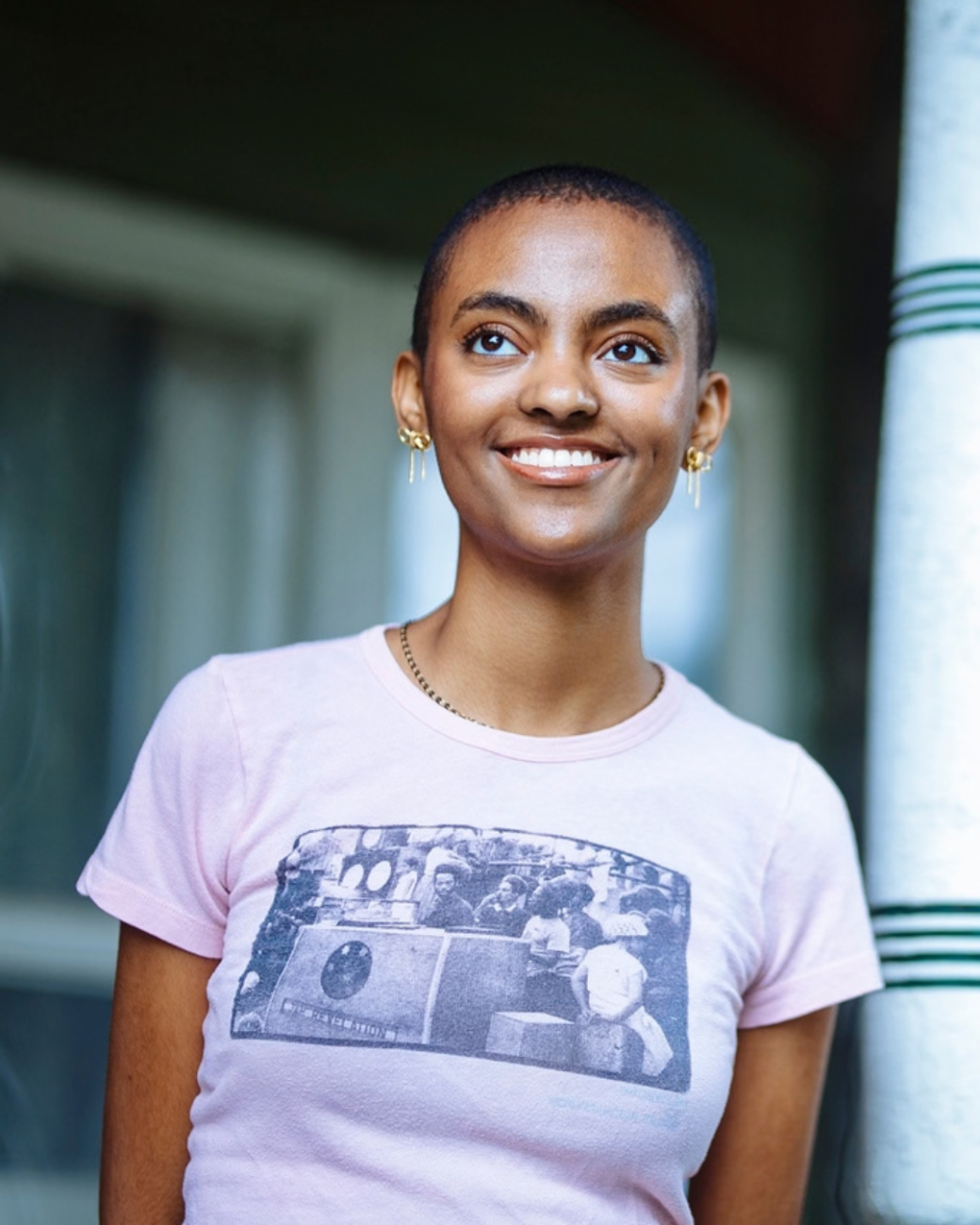 Student smiles standing on porch. 