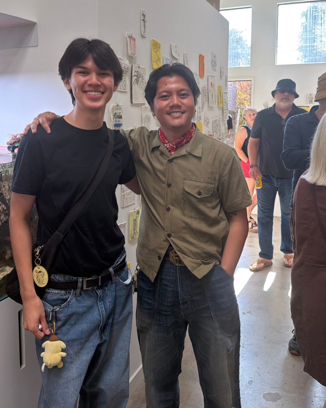 Two people pose for a photo in an art gallery. 