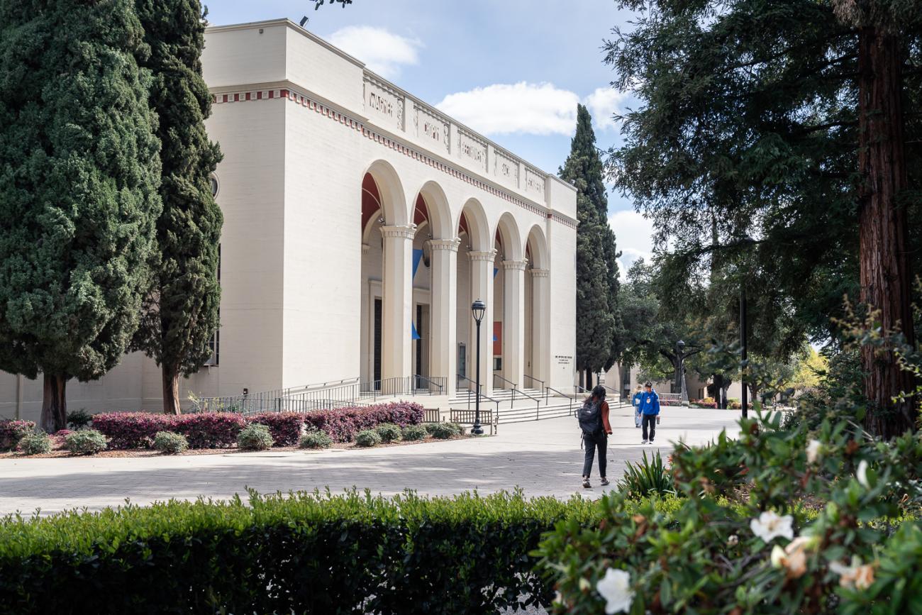 People walk in front of Bridges Auditorium