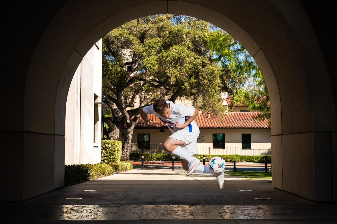 A man kicking a soccer ball into the air