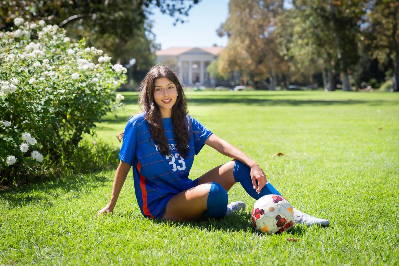 A woman sits on grass