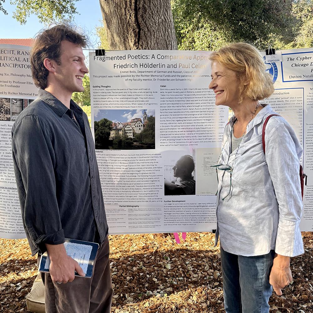 A student and professor stand by the student's SURP poster on Stover Walk during the poster conference.