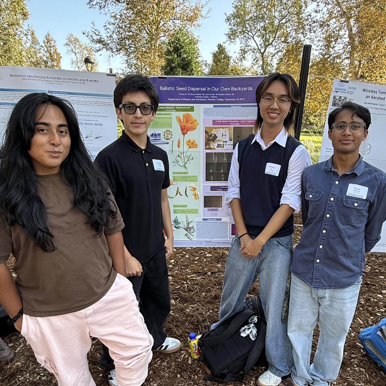 Four students stand with their SURP poster on Stover Walk.