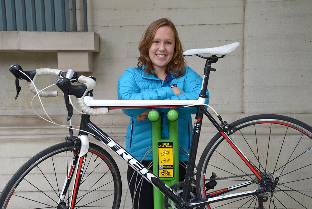 A student with her bike at the bike maintenance station available to students