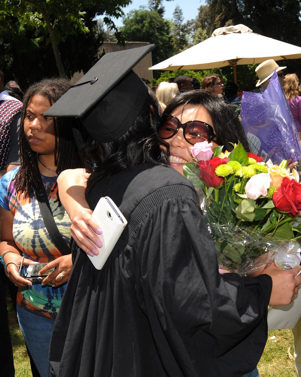 A family hugging at Pomona College Commencement