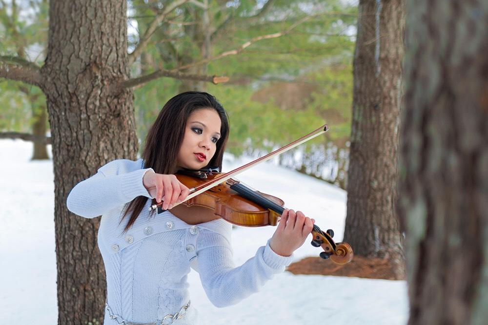 Caroline Fernandez plays the violin in the outdoors.