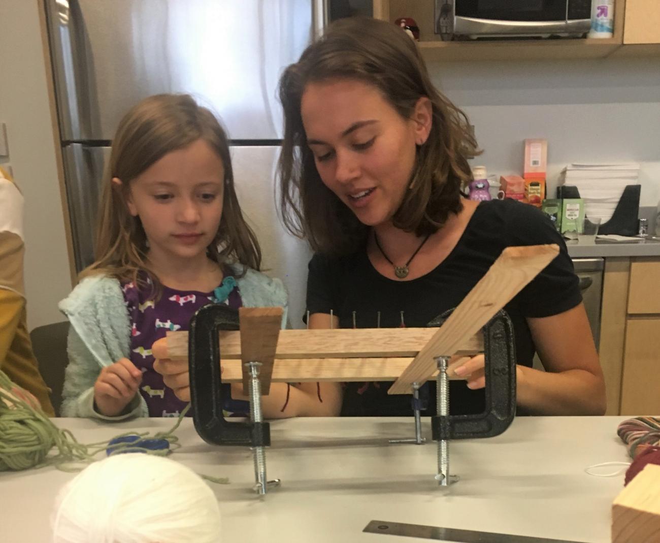 Sara and Avery hand weaving with a mini loom at Feminist Art Day