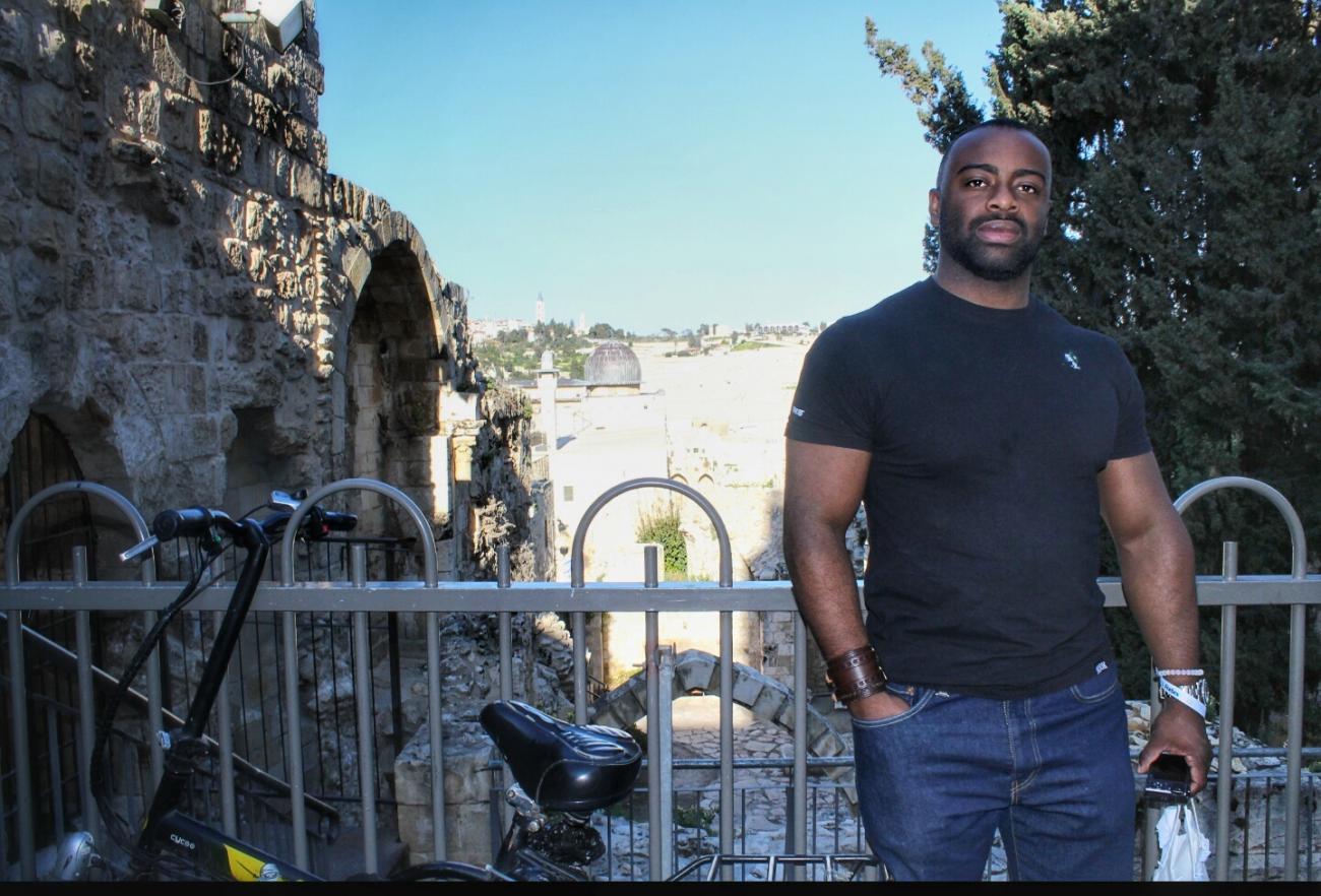 Thurgood Powell, an alumnus, stands with is bike in Jerusalem.