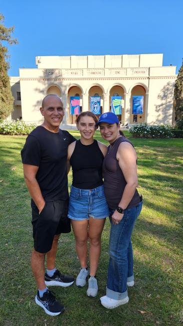 A family of three smiles for a photo