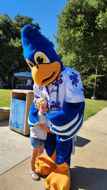 A mascot hugs a child