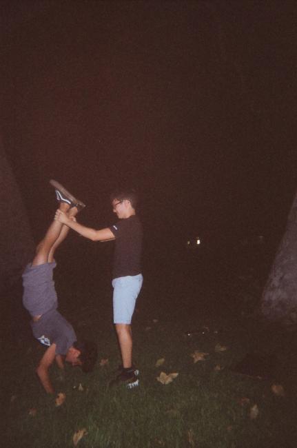 A student holding another student's legs up in the air