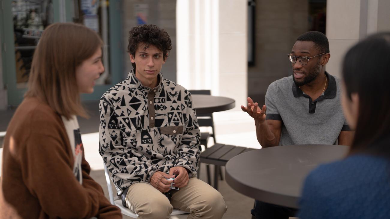 Musa Kamara '22, wearing glasses, leading discussion with group of speaking partners