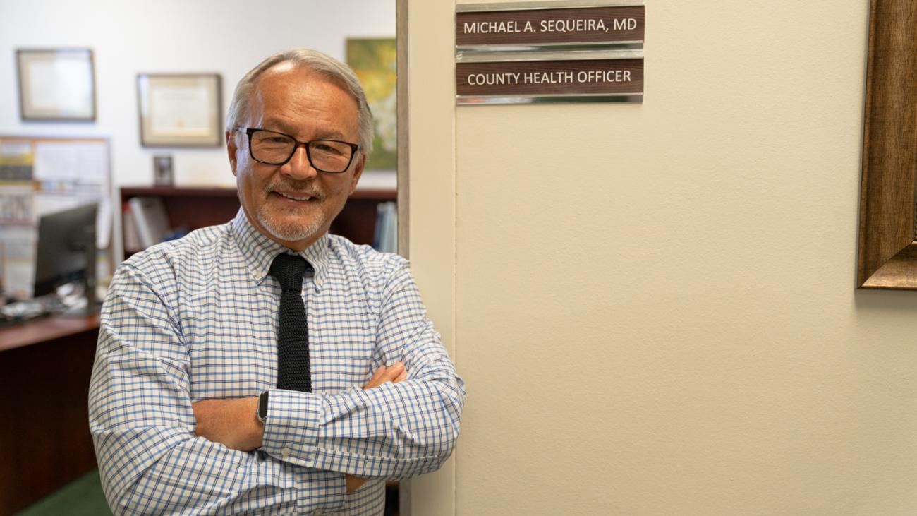 Alumnus Michael Sequeira posing outside his office