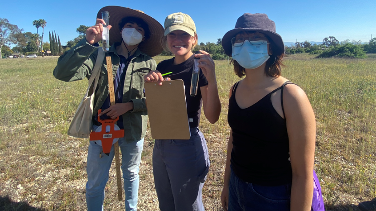 Students collecting pitfall traps to test hypothesis about community ecology