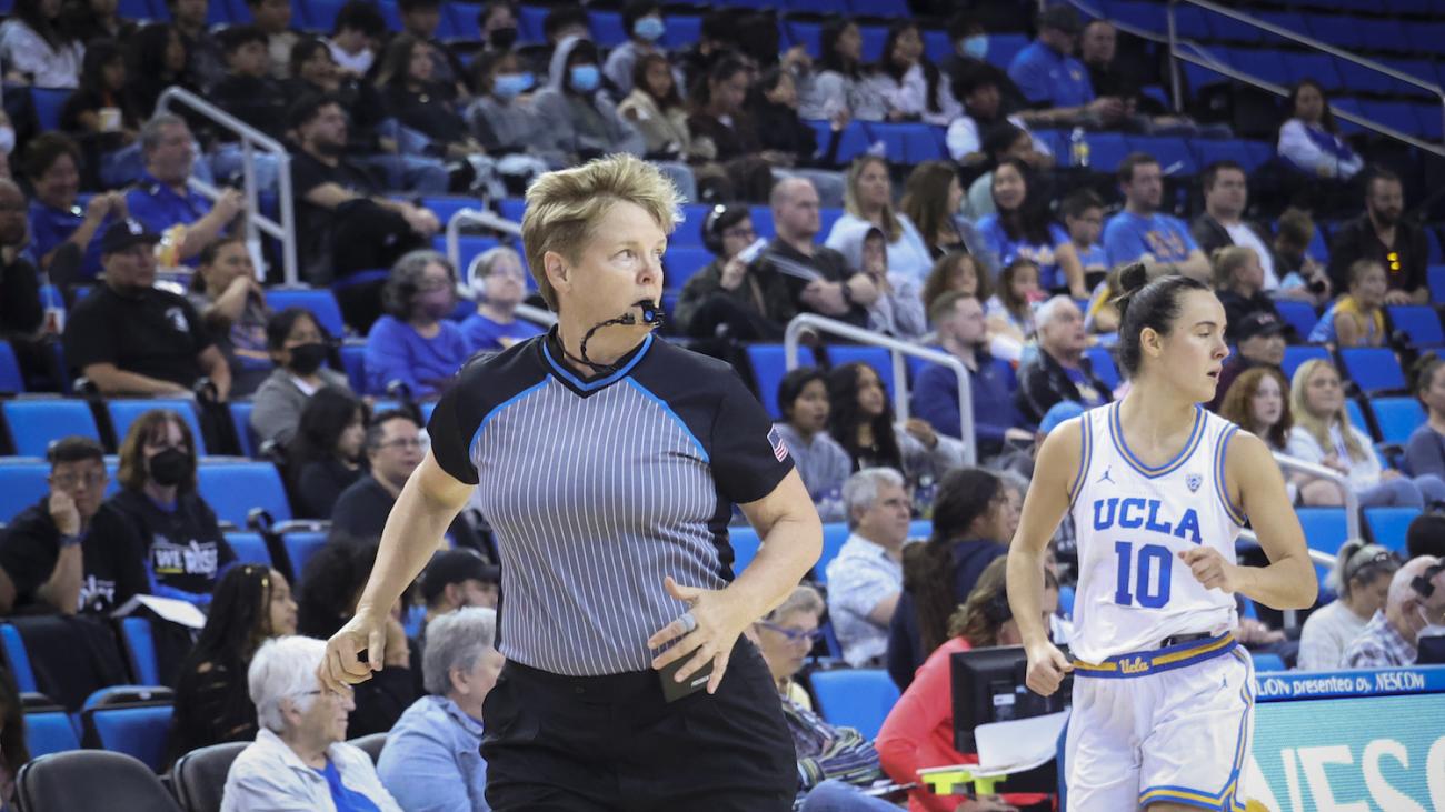 Referee Melissa Barlow '87 running with UCLA player trailing