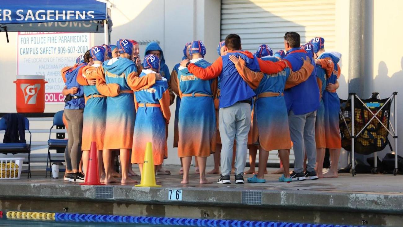 Pomona-Pitzer women's water polo team huddles on pool deck