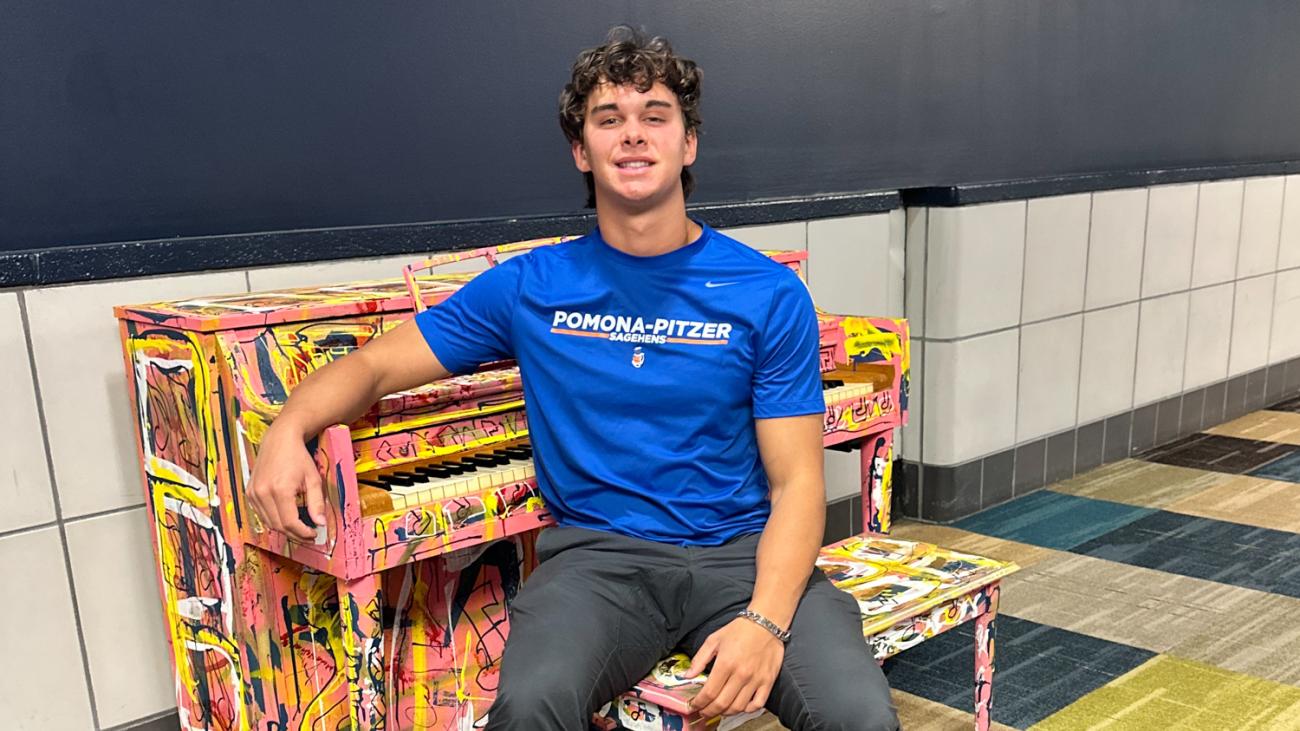 Hudson Colletti sits at a customized piano inside Pittsburgh airport