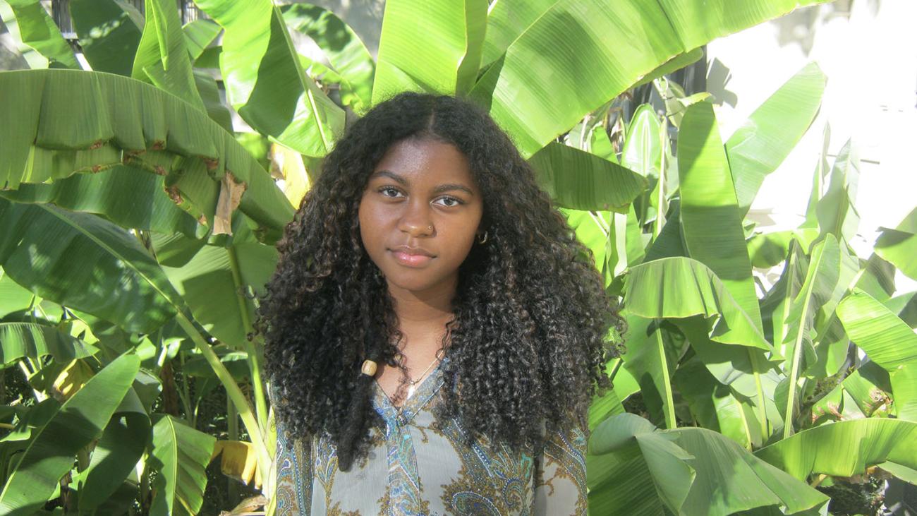 Arianna Lawrence stands in green outdoor setting.