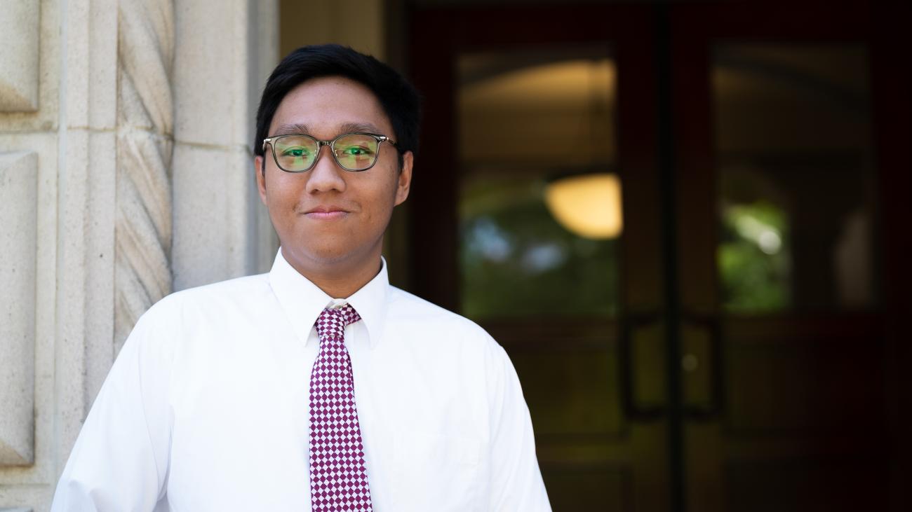 Htet Wai Yan '24 stands in front of a building.