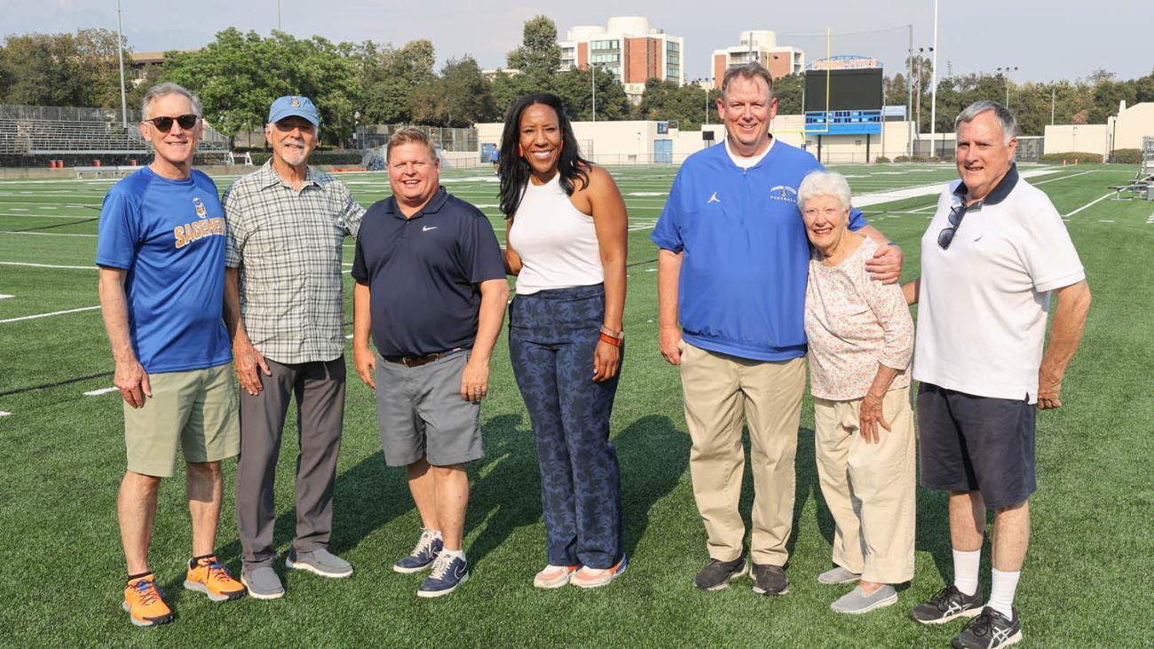 Athletics Director, Miriam Merrill, poses with major donors on Merritt Field