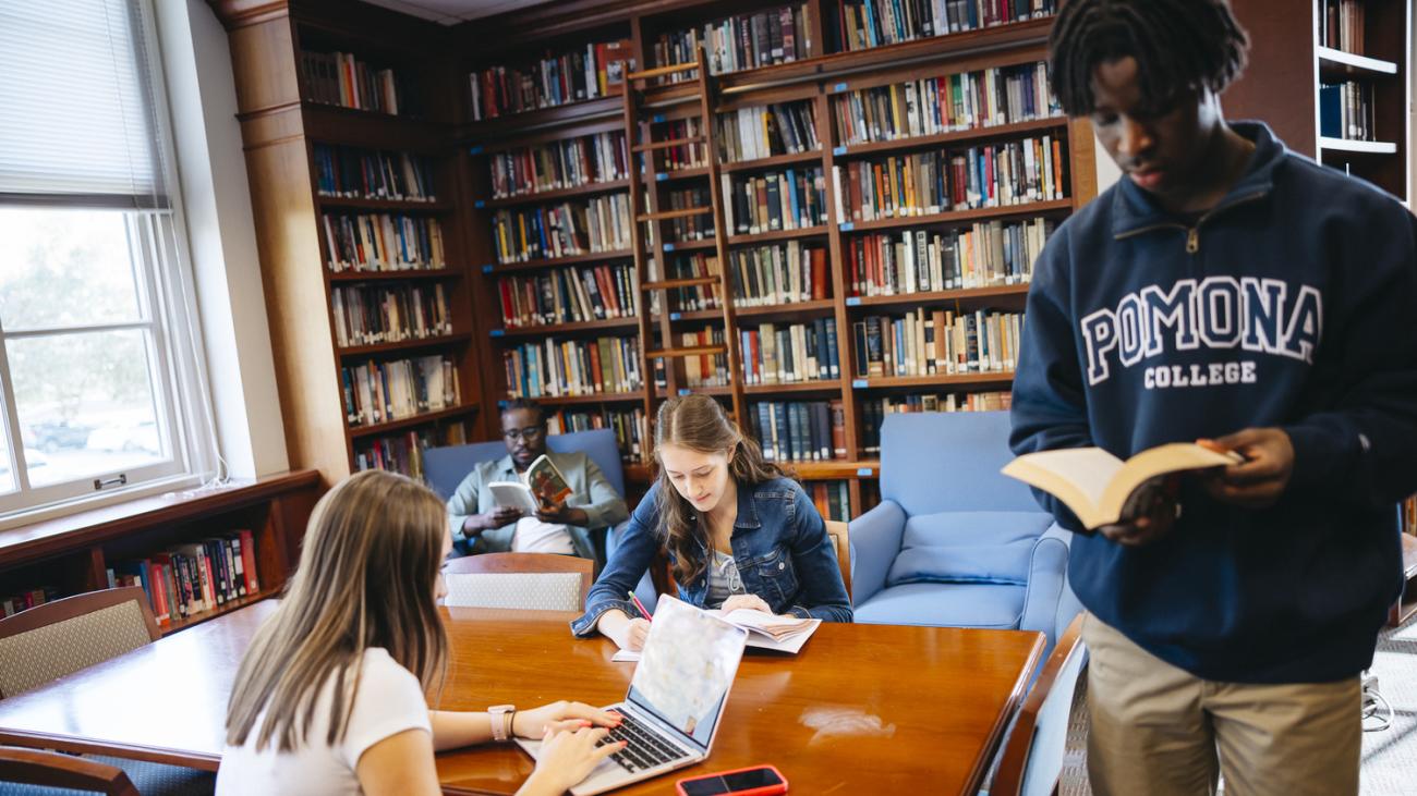 students studying in a small library with sunlight coming through the window