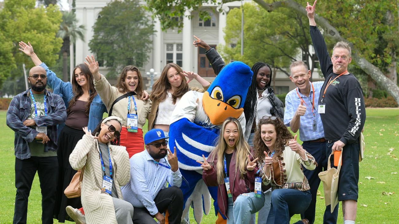 photo of a group of alumni with Cecil on Marston Quad with Carnegie Building in the background