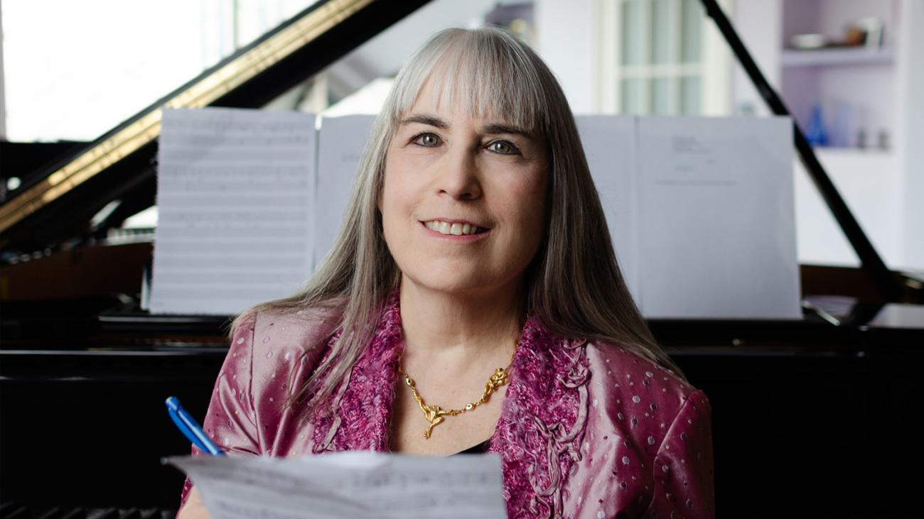 Composer Lori Laitman with sheet music at the piano