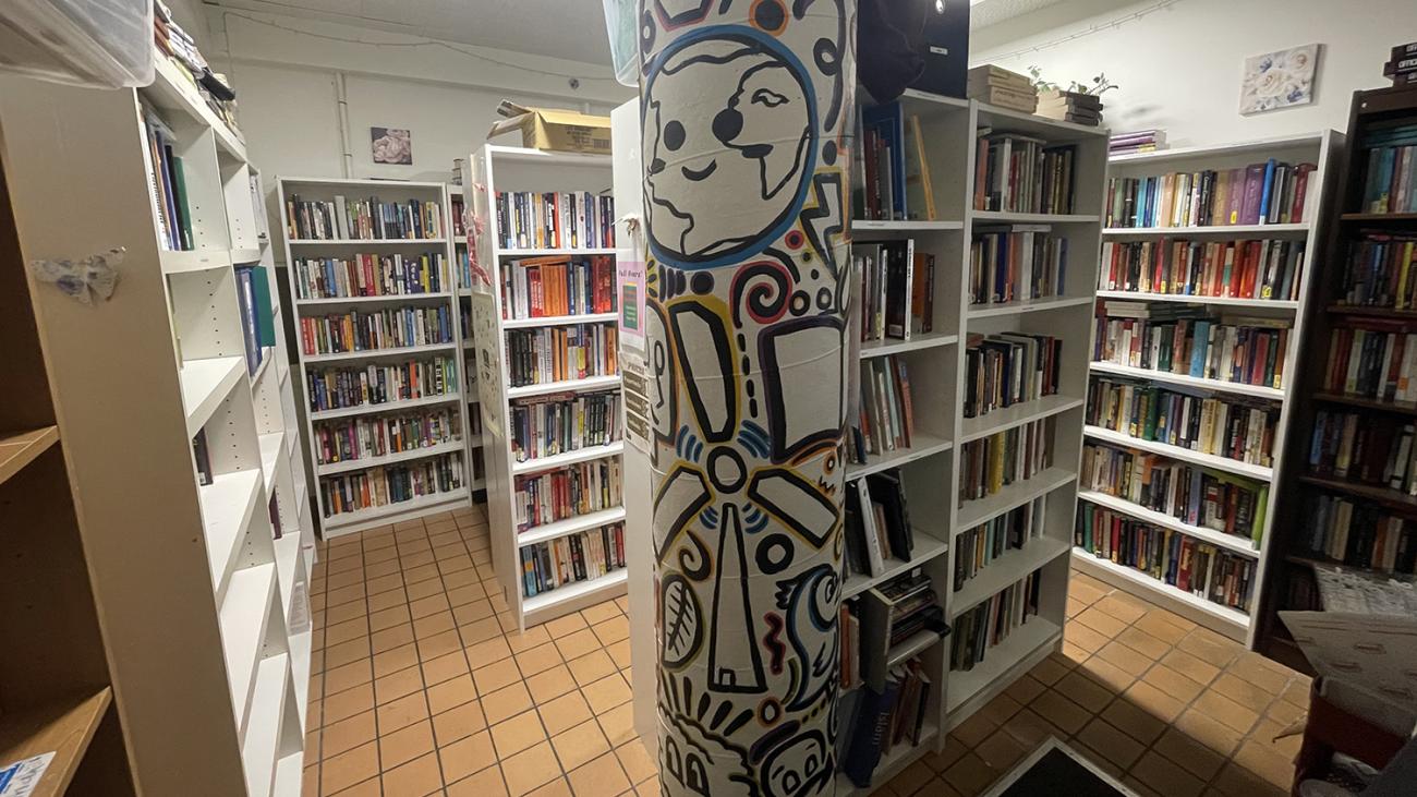 Room with many white shelves filled with books