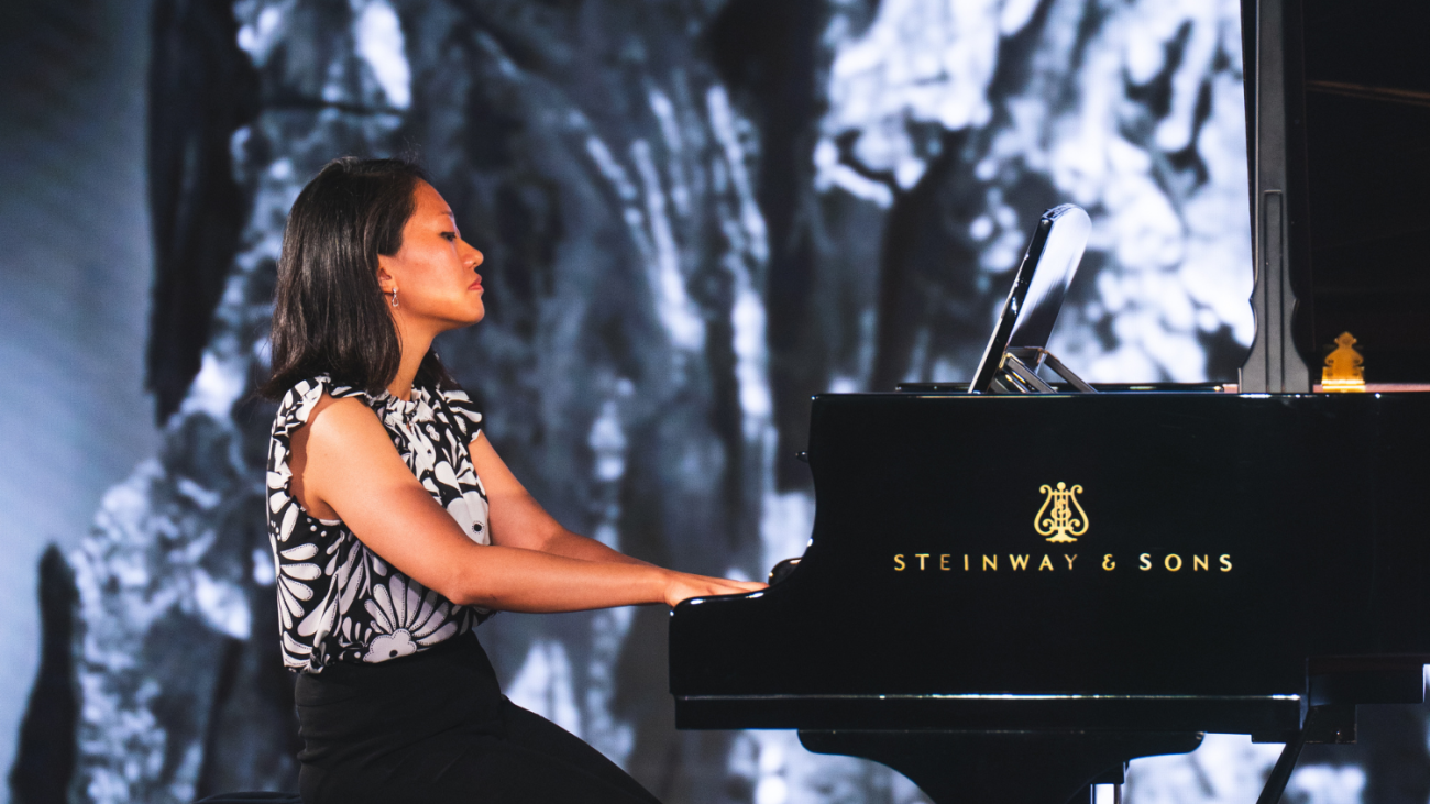 Ania Vu at the piano with abstract background