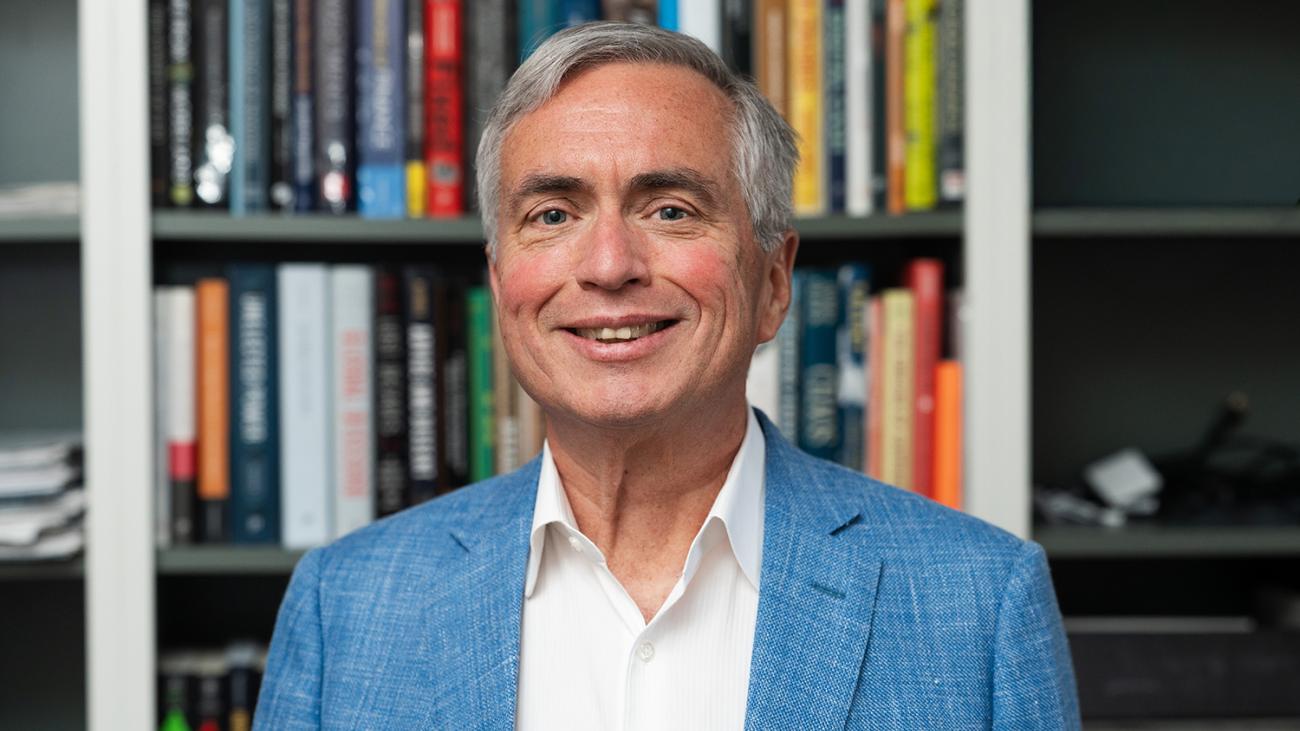 Professor Mico Loretan in front of a bookcase