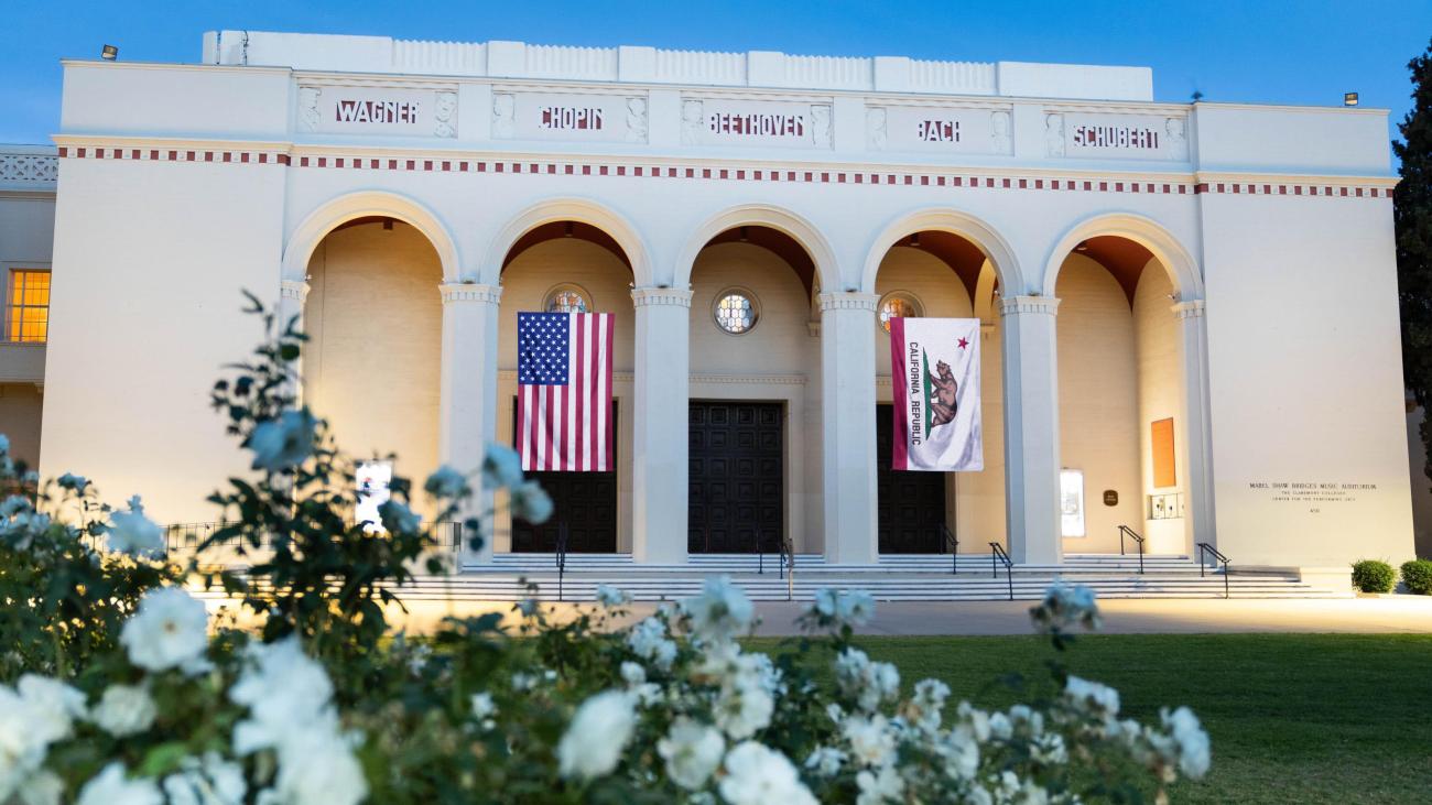Bridges Auditorium exterior with American flag and California flag