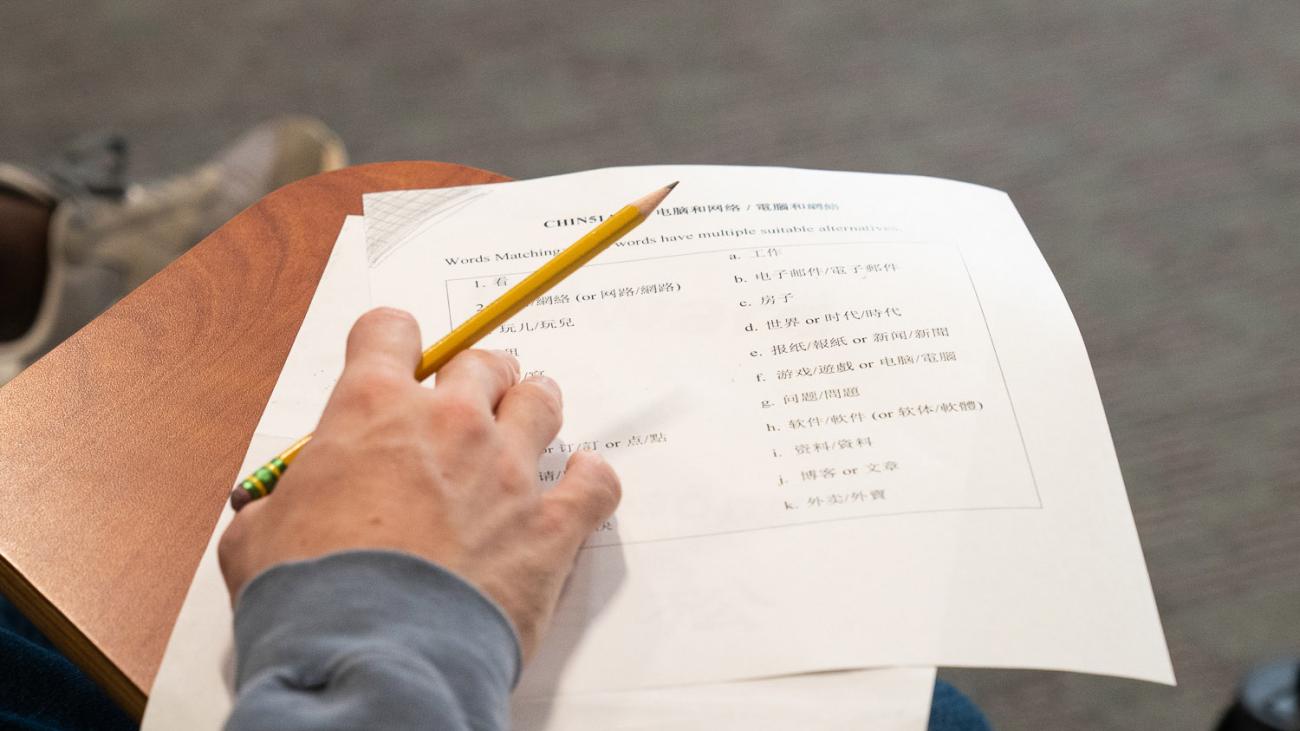 Chinese class course paper and hand holding pencil